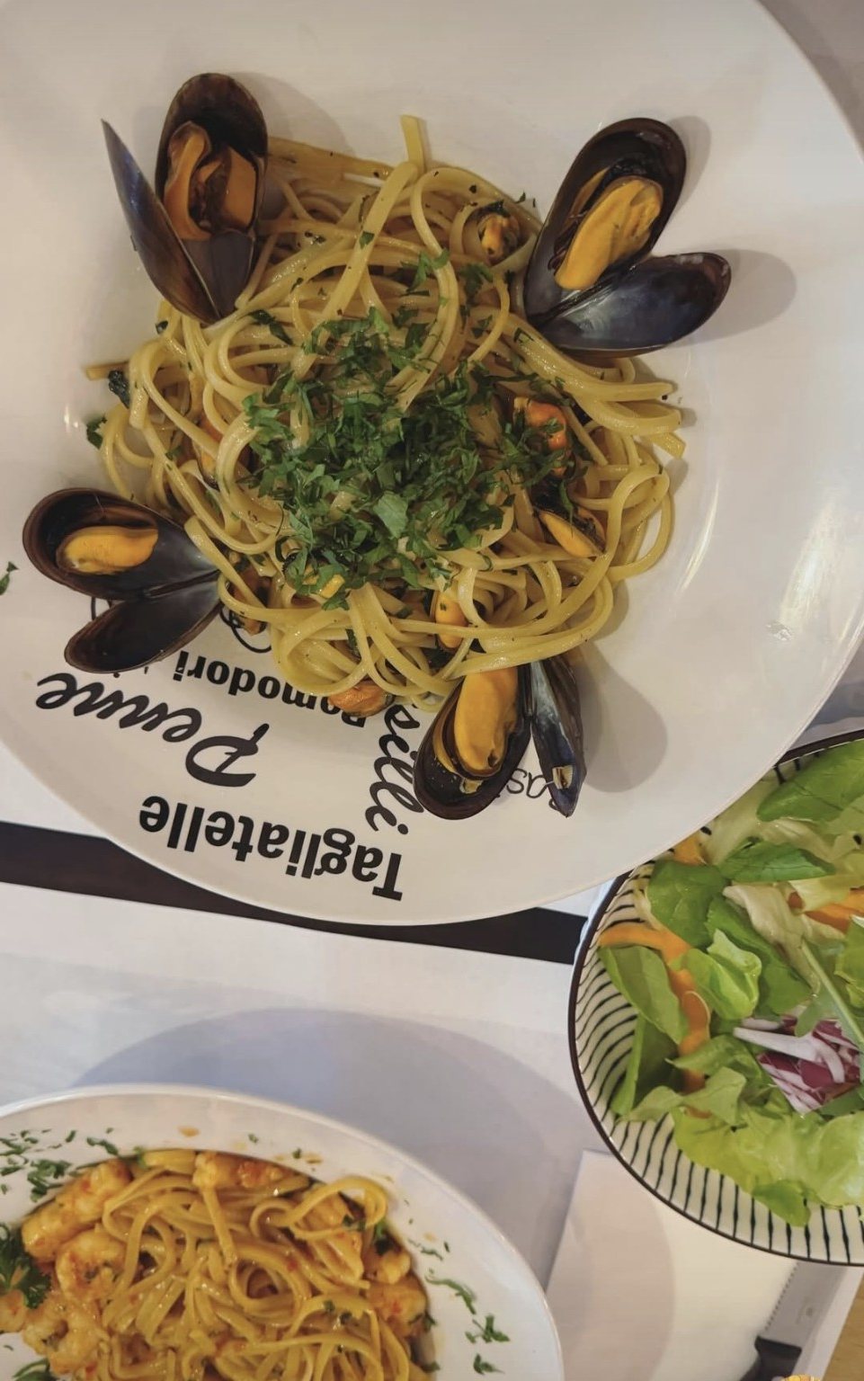 Assiette de pâtes aux moules, servie à table.