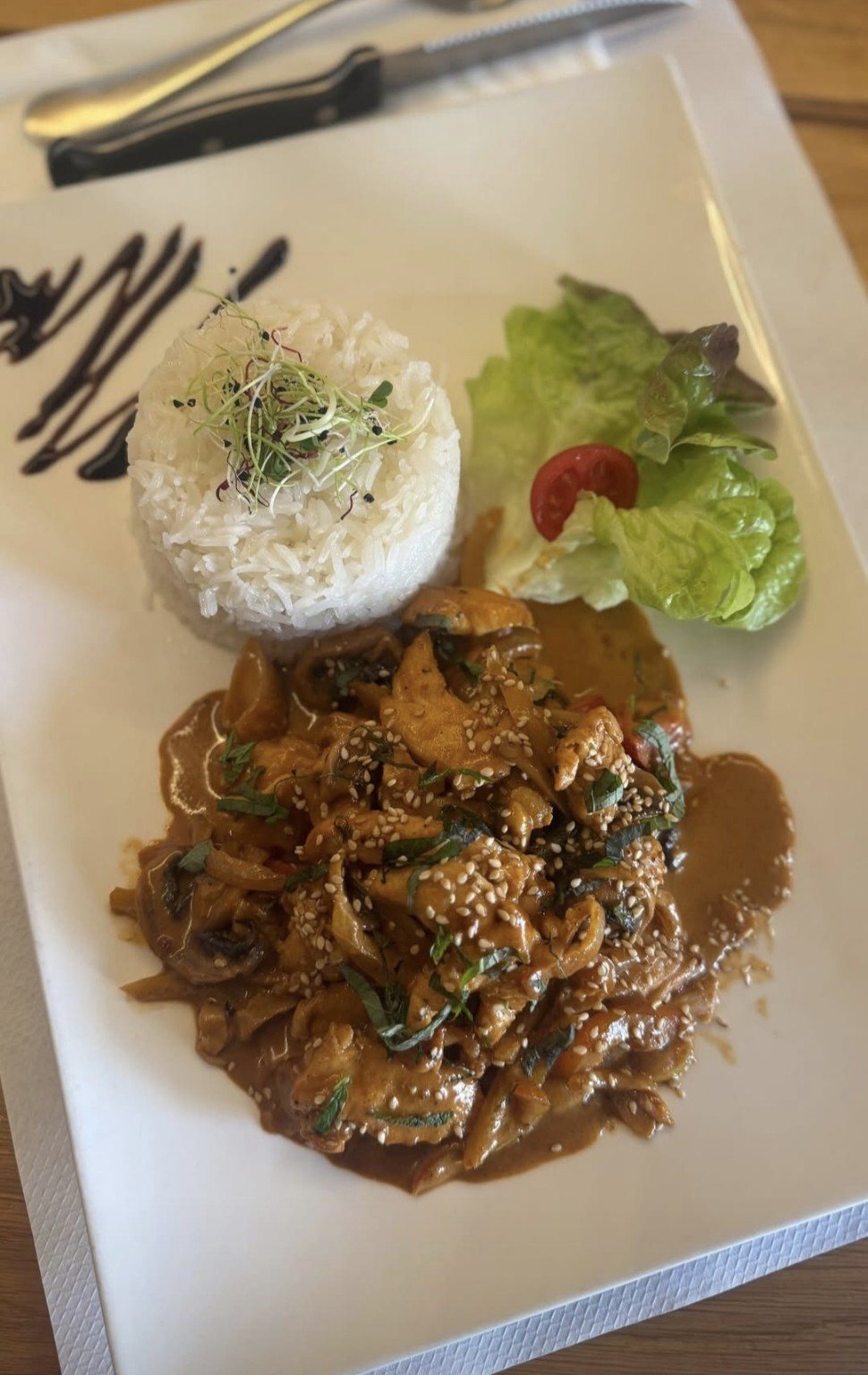 Plat du restaurant, servi avec du riz et une salade.